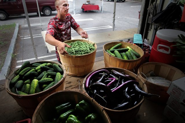 Kevin Bragg of Kimball Fruit Farm unloads produce at the Brookline Farmers Market in Coolidge Corner